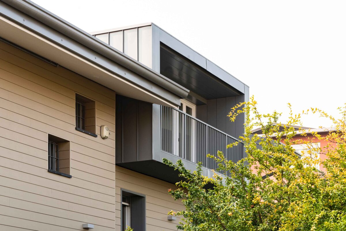 vista ravvicinata di un abbaino moderno con balcone rivestito in metallo su facciata contemporanea